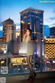 A woman standing on top of a building next to a city.