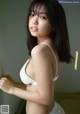 A woman in a white bra and panties posing for a picture.