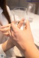 A woman holding a glass of water in her hands.