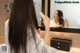 A woman brushing her hair in front of a mirror.