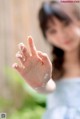 A little girl is holding her hand up in the air.