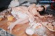 A woman laying on top of a table covered in food.