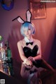 A woman in a bunny costume sitting at a bar.