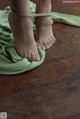 A woman's bare feet tied up on a green cloth.