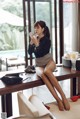 A woman sitting on top of a wooden table.