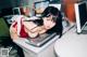 A woman laying on top of a desk next to a printer.