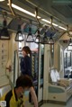 A woman wearing a face mask on a subway train.