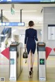 A woman in a blue dress is walking through an airport.