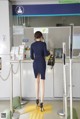 A woman in a blue dress standing in front of a counter.