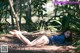 A woman laying on top of a pile of bamboo.