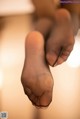 A close up of a person's feet in black stockings.