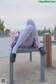 A woman sitting on a bench with her legs crossed.