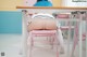 A woman sitting at a desk with her back to the camera.