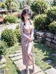 A woman in a kimono standing on a wooden walkway.