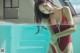 A woman in a red bathing suit standing in a pool.